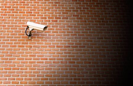 Surveillance camera on a brick wallの写真素材