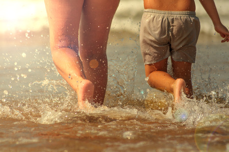 Mother and son happy couple running on the beachの写真素材