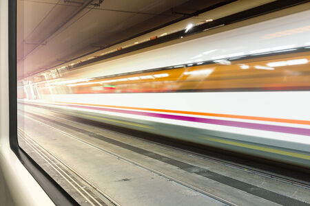 Streamlined train with motion blur moves in tunnel seen from another trainの写真素材
