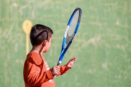 Young boy playing tennis on a courtの写真素材