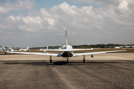 Private small single piston aircraft on airport runway. Small sports plane scrolls on the runway on a sunny day in Fort Myers, Floridaの写真素材