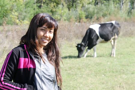 Asian farmer girl or woman posing with cowの写真素材