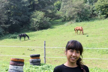 Asian woman posing in horse farmの写真素材
