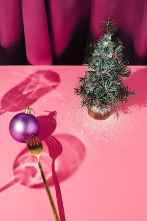 Creative concept made with violet curtain,golden fork ,Christmas decoration and tree. New Year background.の写真素材
