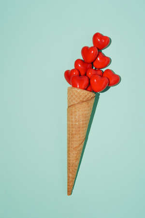 Creative Valentines or womanâs day concept,  celebrating love. Ice cream cone with hearts on green mint background.の写真素材