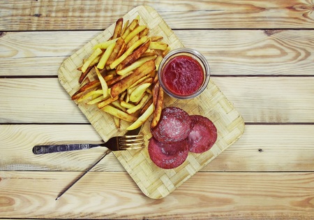 Fried potatoes with sausage with red sauce.