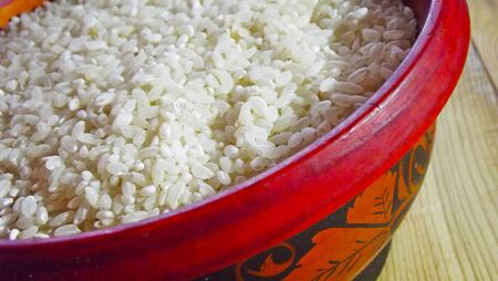Groats rice in a wooden plate.の写真素材