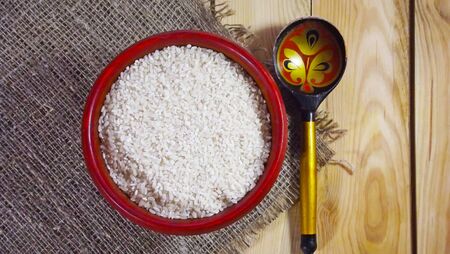 Groats rice in a wooden plate.の写真素材