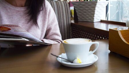 Girl drinking coffee in a cafe.の写真素材