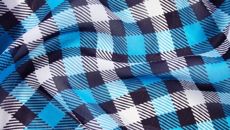 Checkered blue and white background made of light fabric.