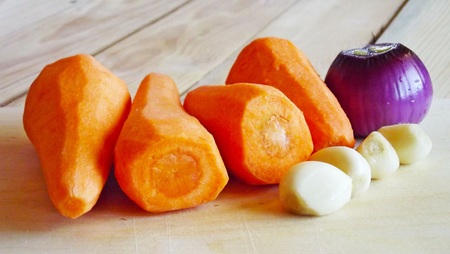 Carrots and onions on a wooden background.の写真素材