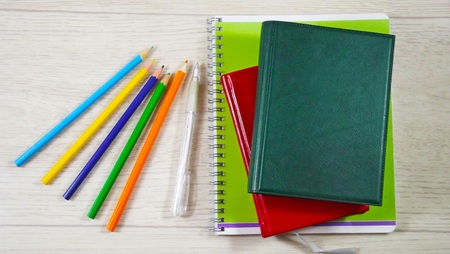 Notebooks and pencils on wooden background.の写真素材