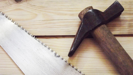 Hammer and saw on wooden background.の写真素材