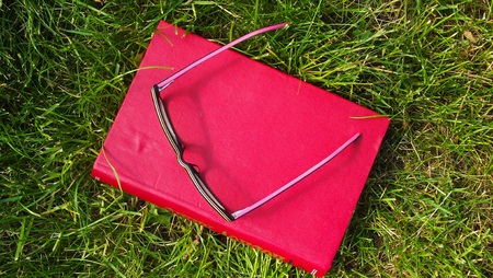 Books and glasses on the grass.Reading in the open air.の写真素材