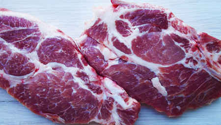 A piece of raw meat on a wooden background.の写真素材