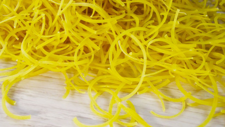 Homemade egg noodles on wooden background.