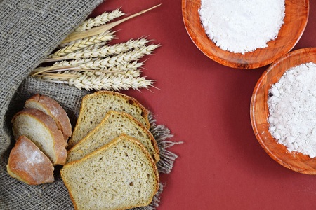 Fresh homemade bread, flour and ears on wooden background.の写真素材