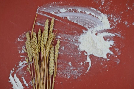 Flour and wheat ears on wooden background.の写真素材