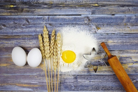 Dough prepartion. Egg, flour and mold  on wooden background.の写真素材