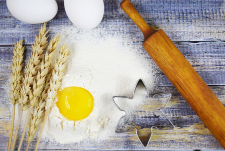 Dough prepartion. Egg, flour and mold  on wooden background.の写真素材