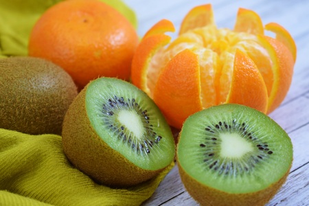 Delicious and fresh tangerines and kiwis on wooden background.の写真素材