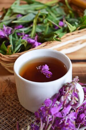 Traditional Russian herbal drink. Ivan-tea in a Cup close-up on a wooden table. It has a positive effect on the human body.の写真素材