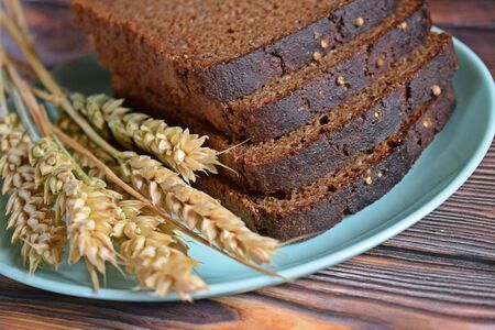 Delicious rye bread with coriander on wooden background.