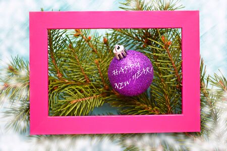 Christmas card.Purple Christmas ball on the tree.The pink frame.