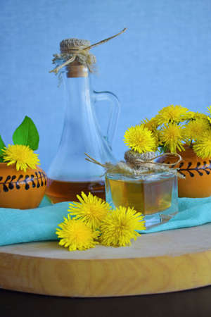 Yellow dandelion flowers and medicinal tincture on a blue background.の写真素材