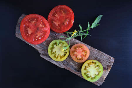 Rijpe tomaten op een zwarte achtergrond. Heerlijk vegetarisch eten.