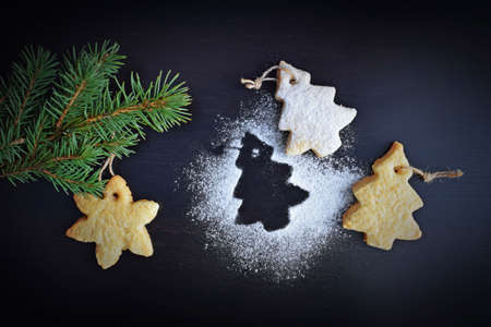 Homemade Christmas cookies and a Christmas tree on a wooden background.Winter holiday.