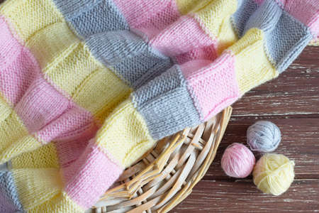 Yarn and knitted fabric on a wooden background.