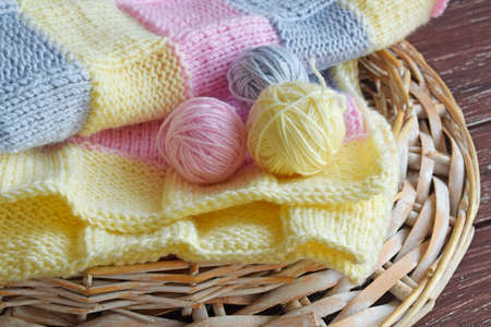 Yarn and knitted fabric on a wooden background.