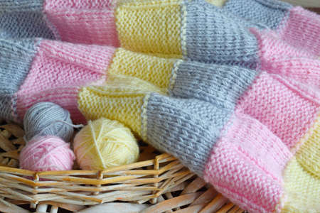 Yarn and knitted fabric on a wooden background.
