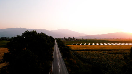 Sunset over the field and mountains in the backgroundの写真素材