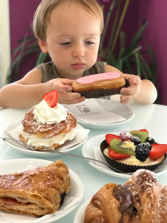 Portrait of a Little Boy Choosing a Cake. difficulty of choice