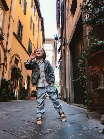 Happy little boy on narrow cobbled street of ancient town. Child on vacationsの写真素材