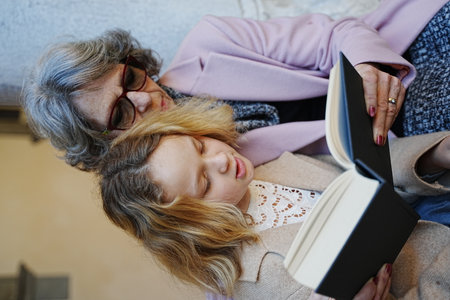 Grandmother and granddaughter reading a bookの写真素材