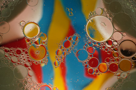 Abstract macro photography of oil droplets suspended in water, creating a mesmerizing pattern of...