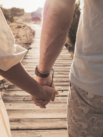 Hand in hand walk together on the road of life. Good relationship and active lifestyleの写真素材