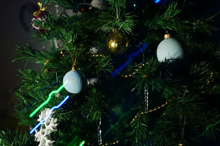 A beautifully decorated Christmas tree adorned with blue and gold ornaments and illuminated by...