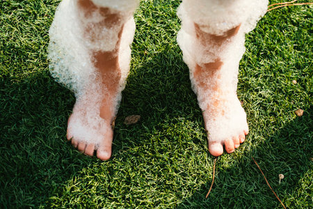 Bare Feet Covered in Soap Bubbles on Grassの写真素材