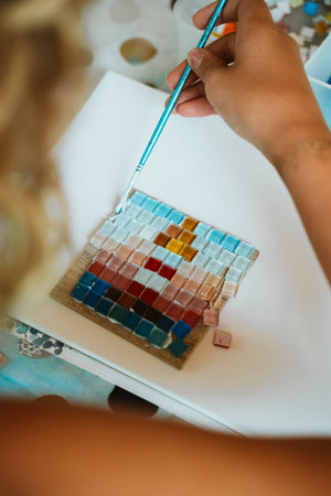 Child Creating Vibrant Mosaic Art with Tilesの写真素材