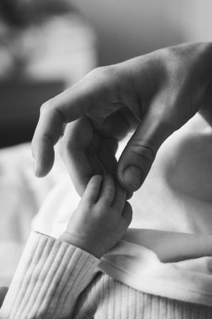 Tender Moment of Baby Grasping Adults Handの写真素材