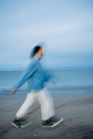 Motion Blur of Person Walking on Beachの写真素材