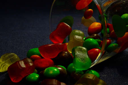 Colored marmalade spilled out of the glassの写真素材