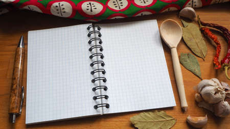 Cooking Board with Notepad on the background of a wooden spoon and spices