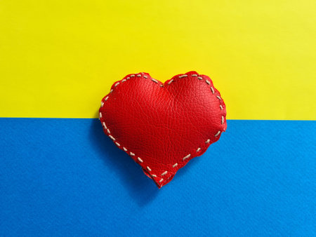 Red heart on background of Ukrainian flag. aid to Ukraine after war. Volunteering protection and safety conceptの写真素材