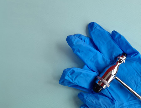Hammer jerk in gloves on blue background surgery in concept. ENT medical healthcare with copy spaceの写真素材