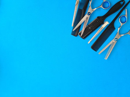 Comb scissors and accessories for hairdressers on blue background. Training hairdressers stylists conceptの写真素材